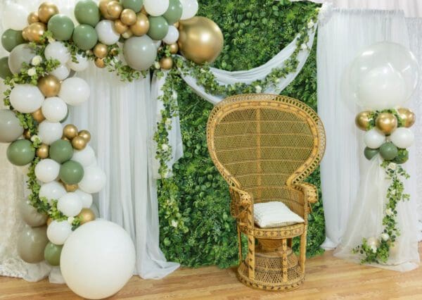 Greenery wall with guest of honor chair and organic balloons